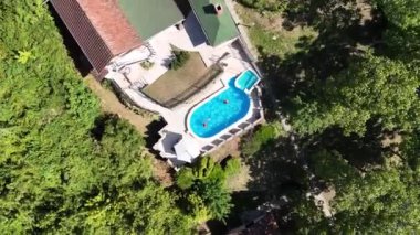 Yüzme havuzu ve terası olan lüks bir villa manzarası.