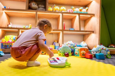 Bebek, yaratıcılığı, duyusal becerileri ve bilişsel gelişimi arttırmak için renkli bir müzikal piyanoyla eğitici aletlerle dolu güvenli ve canlı bir oyun alanında meşgul oluyor.