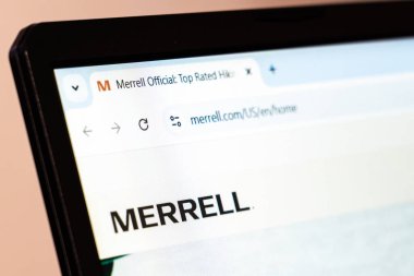 New York, ABD - 26 Ocak 2025: Merrell web sitesi açık hava ayakkabı ve giysi sergilenen bir dizüstü bilgisayar ekranında sergilendi