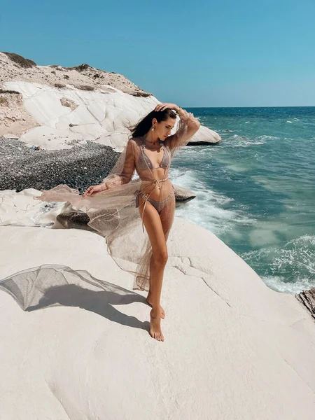 穿着雅致泳衣 一头乌黑头发的美女在岩石沙滩上摆姿势的户外时尚照片 — 图库照片