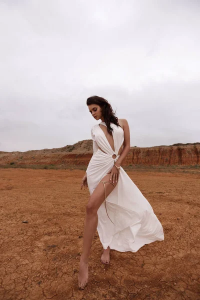 塞浦路斯沙漠中穿着华丽的白衣 头戴黑发 头戴配饰的漂亮女人的户外时尚照片 — 图库照片
