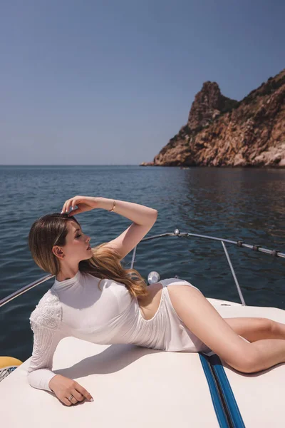 흰옷을 갑판에서 쉬면서 바다를 항해하는 아름다운 머리를 아름다운 여인의 — 스톡 사진