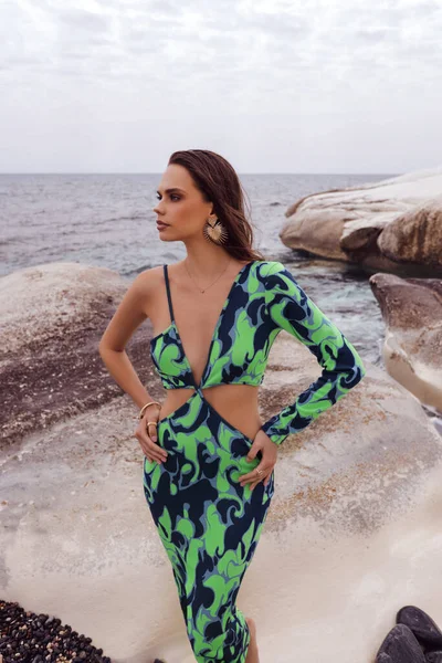 エレガントな服やアクセサリーで暗い髪を持つ美しい女性のファッション屋外写真キプロスの海の近くの白い岩の上にポーズ — ストック写真