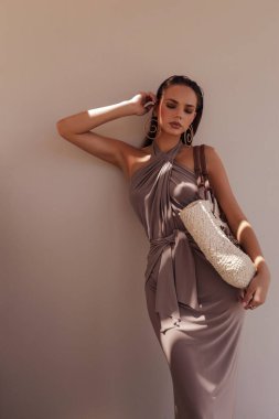 Kıbrıs 'ta yaz plaj kulübünde poz veren şık elbiseli, koyu renk saçlı güzel bir kadının moda fotoğrafı.