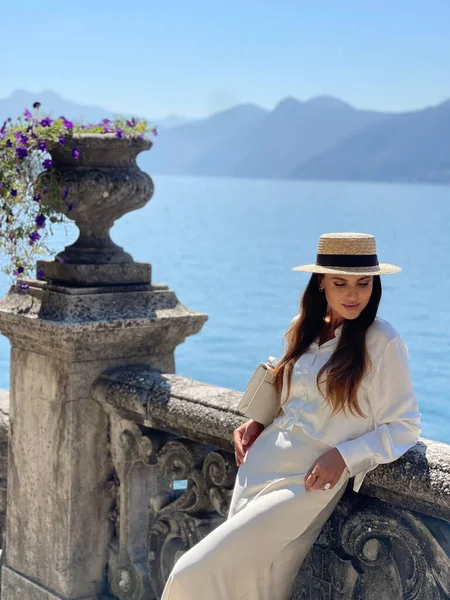 イタリアのコモ湖で豪華なヴィラでポーズエレガントな服で暗い髪の美しい女性のファッション屋外写真 — ストック写真