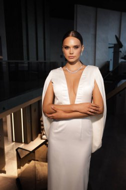 Zarif gelinlik ve aksesuar içinde şık bir otel odasında poz veren güzel gelinlerin moda fotoğrafı.