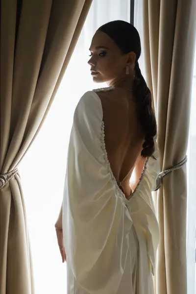 エレガントなホテルの部屋にポーズするエレガントなウェディングドレスとアクセサリーで美しい花嫁のファッション写真 — ストック写真