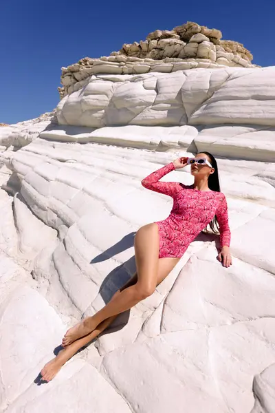 キプロスの白い岩のビーチでポーズを印刷エレガントな印刷されたビーチ服で暗い髪の美しい官能的な女性のファッション屋外写真 ストック写真