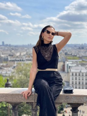 Montmartre 'da panoramik manzaralı, şık giyinmiş, siyah saçlı güzel bir kadının moda fotoğrafı.