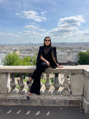 Montmartre 'da panoramik manzaralı, şık giyinmiş, siyah saçlı güzel bir kadının moda fotoğrafı.