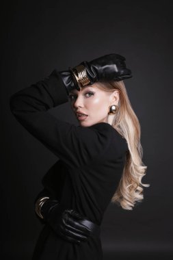 Güzel Slav bir kadının moda fotoğrafı. Uzun sarı saçlı, şık kıyafetler ve aksesuarlar giyen, stüdyoda poz veren.