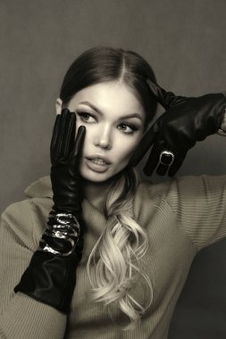 Güzel Slav bir kadının, sarı saçlı, elegang elbiseli, siyah eldivenli ve stüdyoda poz veren güzel bir fotoğrafı.