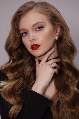 Stüdyoda poz veren siyah kıvırcık saçlı güzel bir kadının moda fotoğrafı.