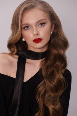 Stüdyoda poz veren siyah kıvırcık saçlı güzel bir kadının moda fotoğrafı.