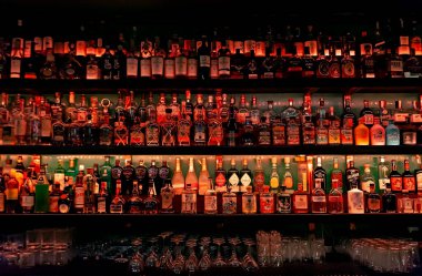 Bottles of alcohol and spirits on backlight shelves at Elixir Cocktail Bar in Sibiu, Romania