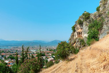 Amyntas 'ın mezarı, arka planda Fethiye şehir manzaralı eski Lycia kaya mezarları