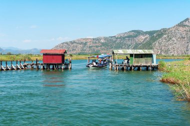 Türkiye 'de Dalyan nehri üzerindeki eski balıkçı teknesi ve kapısından geçiyor