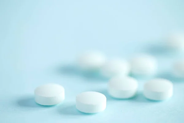 White medical pills on blue background
