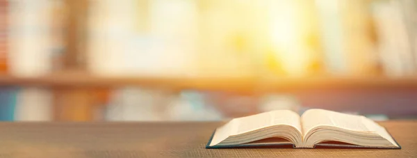 Eğitim kavramı. Kütüphanedeki ahşap masada açık bir kitap.