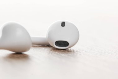 Kahverengi ahşap arka planda beyaz kulaklıklar