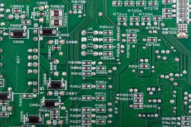 Yeşil baskılı devre kartının (PCB) rezistanslar, kondansatörler ve entegre devreler gibi çeşitli elektronik bileşenleriyle detaylı makro görüntüsü. Modern elektronik, bilgisayar donanımı veya teknoloji kavramlarını resmetmek için ideal.