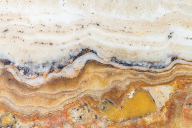 Sarı, kahverengi ve beyaz mineral katmanlı zarif mermer yüzey ham doku ve doğal çizgilerle, arka plan, baskı şablonları veya iç tasarım için mükemmeldir..