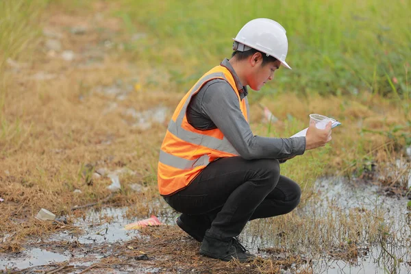 Environmental engineers work at water source to check for contaminants  in water sources and analysing water test results for reuse.World environment day concept.
