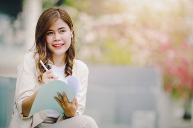 Belgeleri elinde tutan şık bir iş kadını. Ofis kulelerinin etrafında dolanıyor, dışarıda çalışıyor..