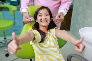 Bu tatlı kız dişçi muayenehanesindeki dişçi randevusuna hazırlanıyor. Çocuk sağlığı konsepti..