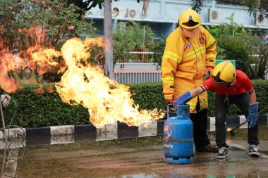 Nakhon Ratchasima, Tayland - 1 Temmuz 2023: Yangın emniyetinin nasıl verileceği ve yangının nasıl söndürüleceği. Çalışan itfaiyeciler, gaz tankı vanasını kapatın..
