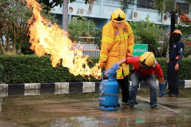 Nakhon Ratchasima, Tayland - 1 Temmuz 2023: Yangın emniyetinin nasıl verileceği ve yangının nasıl söndürüleceği. Çalışan itfaiyeciler, gaz tankı vanasını kapatın..