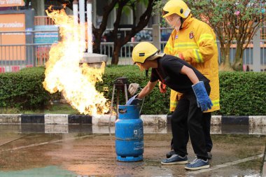Nakhon Ratchasima, Tayland - 1 Temmuz 2023: Yangın emniyetinin nasıl verileceği ve yangının nasıl söndürüleceği. Çalışan itfaiyeciler, gaz tankı vanasını kapatın..