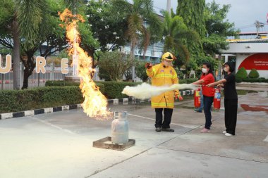 Nakhon Ratchasima, Tayland - 1 Temmuz 2023: Yangın emniyetinin nasıl verileceği ve yangının nasıl söndürüleceği. Çalışan itfaiyeciler yangın söndürücü sıkarak yangını söndürmeye çalışıyorlar.