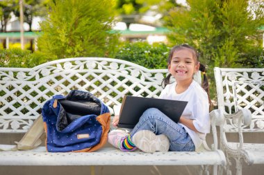 Küçük Asyalı kız, dersten sonra kitap okuyor. Ödev yapmayı öğreniyor. Bu da sınıfın gelişimini arttırıyor ve öğrenme becerilerini geliştiriyor. Okula Dönüş Konsepti.