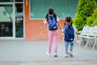 Sırt çantalı küçük Asyalı kız okula eğlenerek gidiyor. Bu da gelişimini arttırır ve öğrenme becerilerini geliştirir. Okula Dönüş Konsepti.