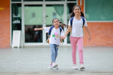Sırt çantalı küçük Asyalı kız okula eğlenerek gidiyor. Bu da gelişimini arttırır ve öğrenme becerilerini geliştirir. Okula Dönüş Konsepti.