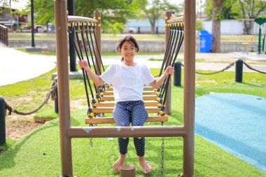 Küçük Asyalı kız, oyun parkında eğlenirken. Bu da sınıfın öğrenme becerilerinin dışında gelişimi ve gelişimi arttırır..