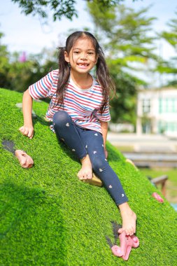 Küçük Asyalı kız, oyun parkında eğlenirken. Bu da sınıfın öğrenme becerilerinin dışında gelişimi ve gelişimi arttırır..