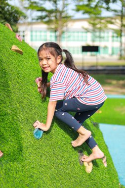 Küçük Asyalı kız, oyun parkında eğlenirken. Bu da sınıfın öğrenme becerilerinin dışında gelişimi ve gelişimi arttırır..