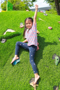 Küçük Asyalı kız, oyun parkında eğlenirken. Bu da sınıfın öğrenme becerilerinin dışında gelişimi ve gelişimi arttırır..