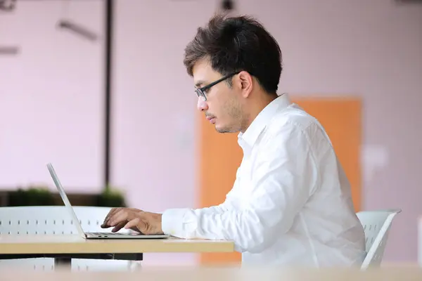 ラップトップコンピュータのワーキングオフィスまたはオンラインショッピング ホームワーク フリーランス オンライン学習とメガネの若いビジネスマン ロイヤリティフリーのストック画像