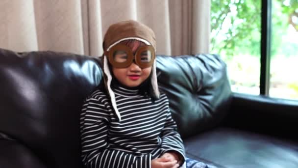 快乐的亚洲小孩在家里戴着飞行员的帽子 — 图库视频影像