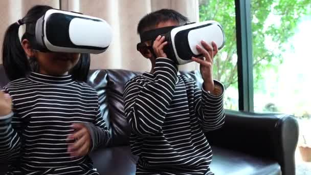 幸せなアジアの小さな男の子と女の子使用してVrメガネで自宅 — ストック動画