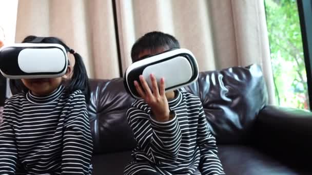 Χαρούμενο Ασιατικό Αγοράκι Και Κορίτσι Που Χρησιμοποιεί Γυαλιά Εικονικής Πραγματικότητας — Αρχείο Βίντεο