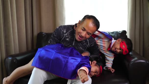 Asiatisk Far Leker Med Sina Små Barn Superhjältedräkter Hemma — Stockvideo