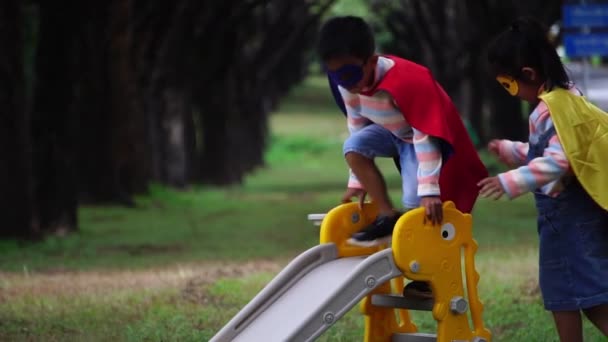 Dwoje Małych Azjatyckich Dzieci Bawiących Się Placu Zabaw Kostiumach Superbohatera — Wideo stockowe