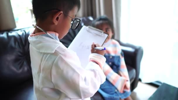 Två Asiatiska Barn Leker Läkare Hemma — Stockvideo