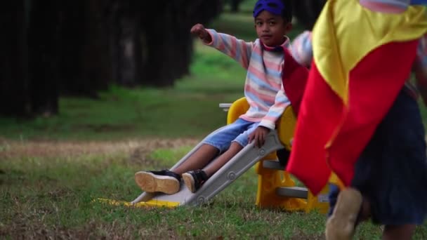 Két Kis Ázsiai Gyerek Játszik Játszótéren Szuperhős Jelmezben — Stock videók