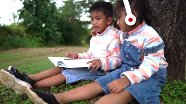 Παιδί Κάθεται Στο Πάρκο Μελετώντας — Αρχείο Βίντεο