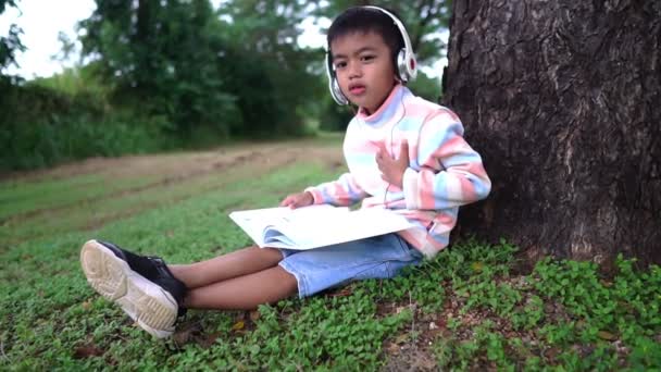 Asyalı Çocuk Parkta Oturmuş Ders Çalışıyor — Stok video